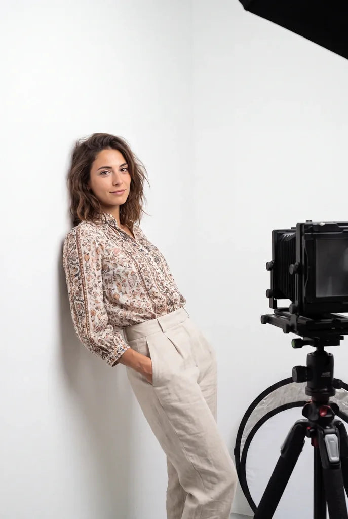 A sitter beside a large-format camera in the studio